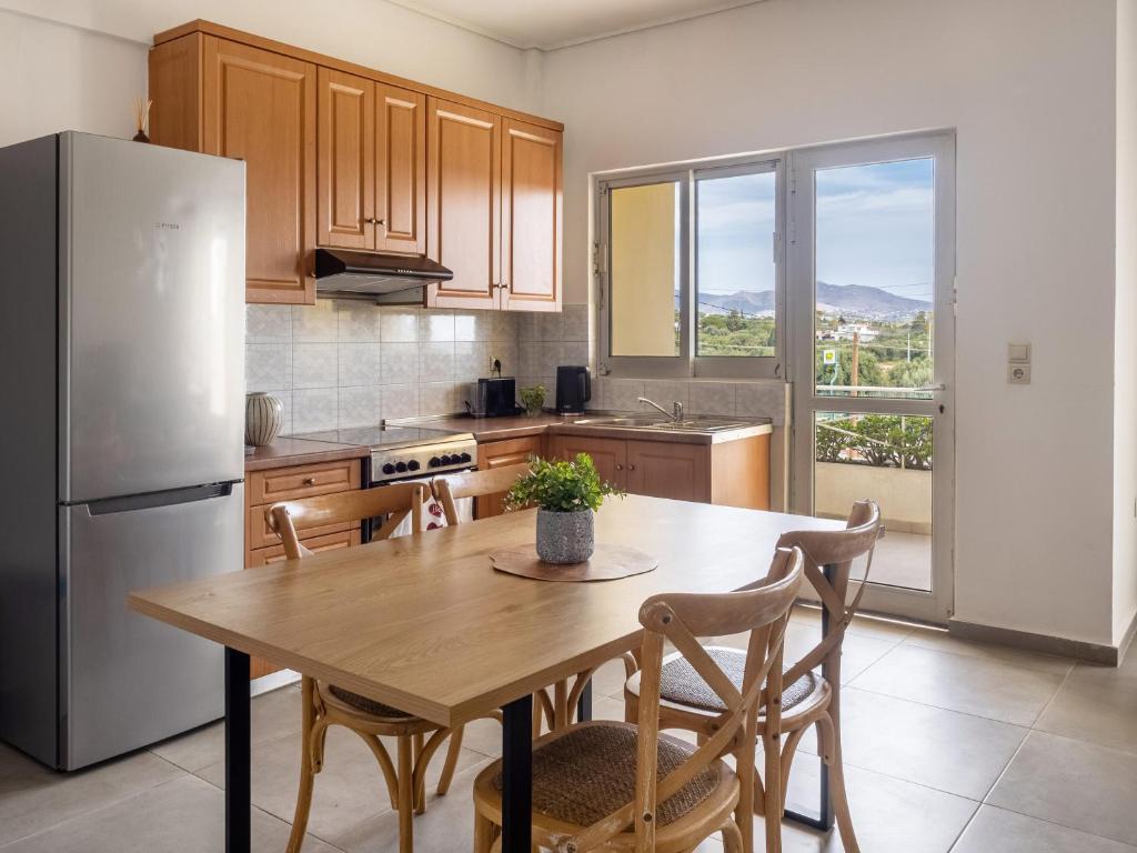 a kitchen with a wooden table and a refrigerator at Sunrise By Athens Airport in Spáta