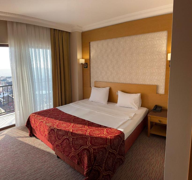 Una habitación de hotel con una cama y una ventana grande. en Mekanhan Hotel, en Gebze