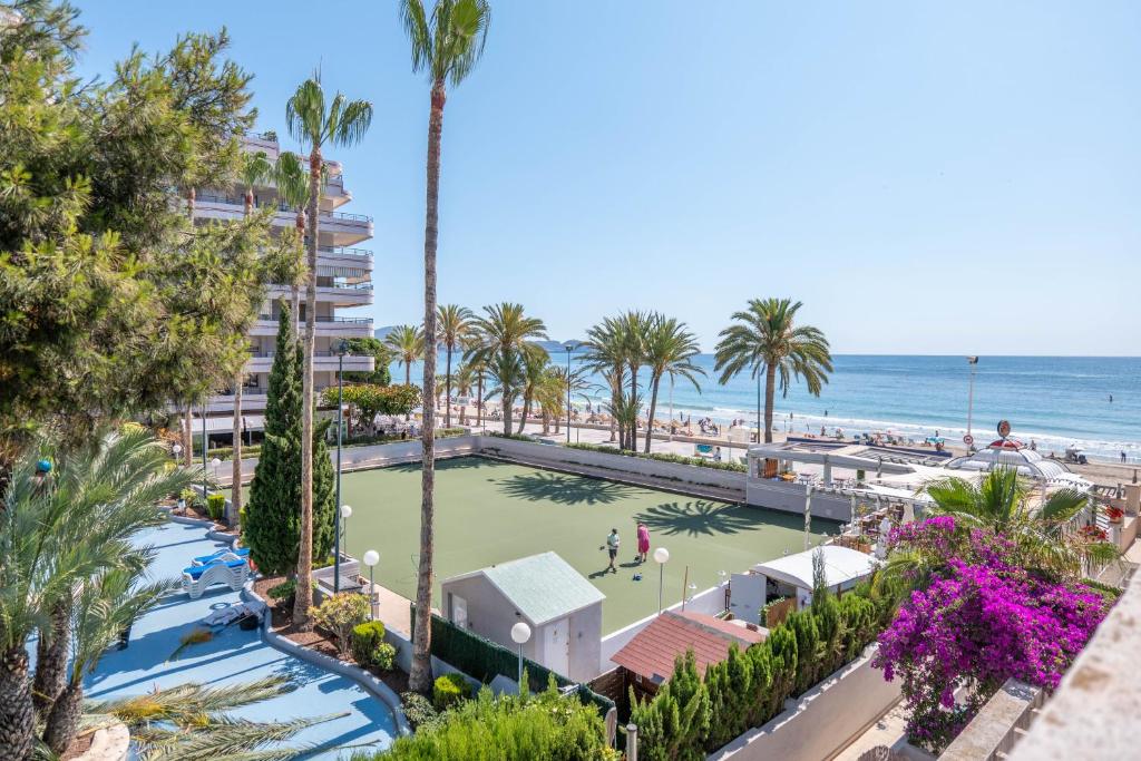 Una vista de la playa desde el balcón de un resort. en Bungalow a pie de playa, en Ifach