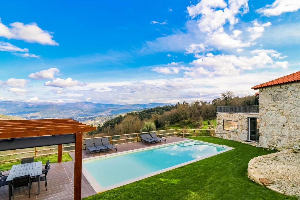a villa with a swimming pool and a patio at Casa Vale do Luar in Celorico de Basto
