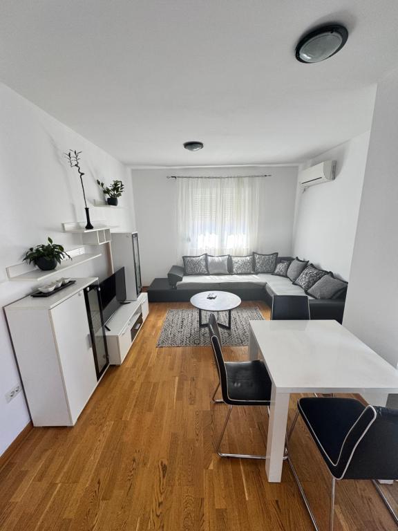 ein Wohnzimmer mit Sofa und Tisch in der Unterkunft City Apartment in Podgorica