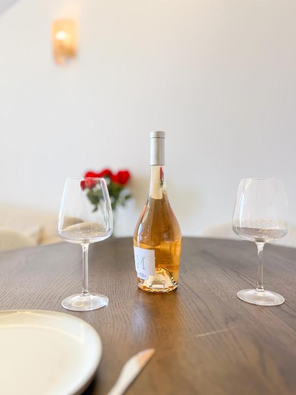 une bouteille de vin posée sur une table avec deux verres dans l'établissement Idéal Appartement sur le Port - VIP, à Saint-Tropez