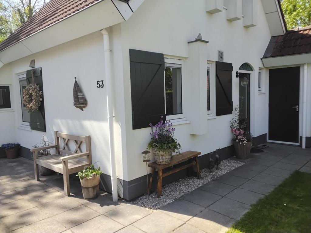 a white house with a bench and windows at Vakantiepark Eysinga State Huize Anna in Sint Nicolaasga