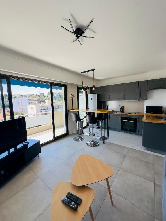 Il comprend un salon avec une cuisine et un ventilateur de plafond. dans l'établissement Apartement 2 pièces, au Cannet