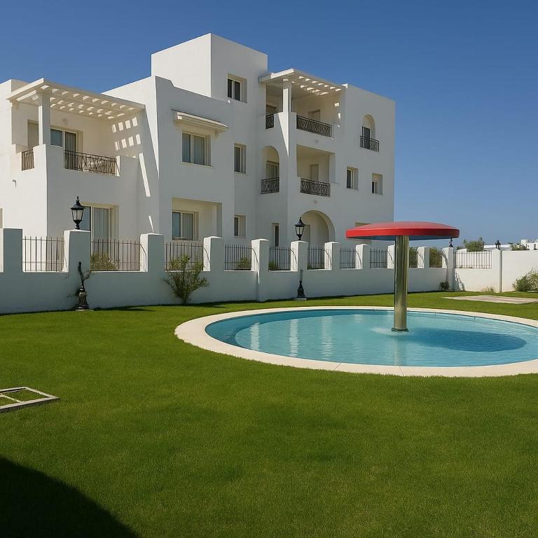 a apartment building with a red frisbee in the yard at résidence Nesrine-Hammemet sud in Hammamet