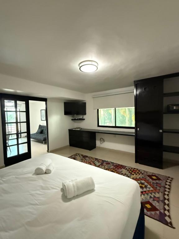 ein Schlafzimmer mit einem weißen Bett mit zwei Handtüchern darauf in der Unterkunft Marazul Hotel Boutique in Isla Mujeres
