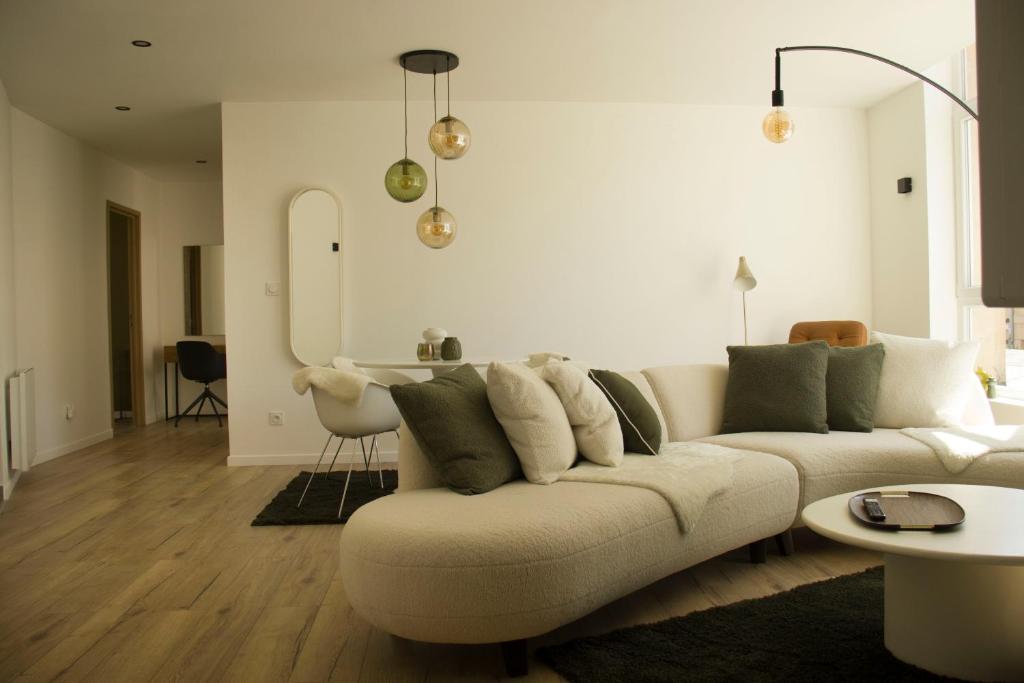 - un salon avec un canapé blanc et des oreillers verts dans l'établissement Suite Izambard 4 pers Standing en centre ville, à Charleville-Mézières