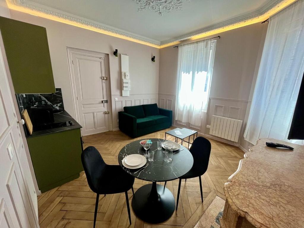 un salon avec une table, des chaises et un canapé dans l'établissement La Violette, à Rouen