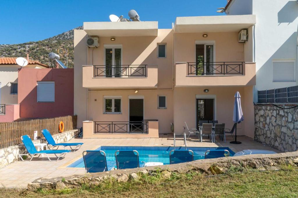a villa with a swimming pool in front of a house at Villa Nikolas in Balíon