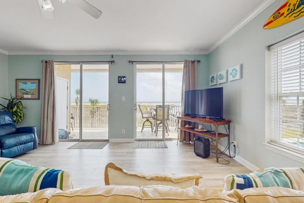a living room with a couch and a tv at Beach Joy - DIBC 206A in Dauphin Island