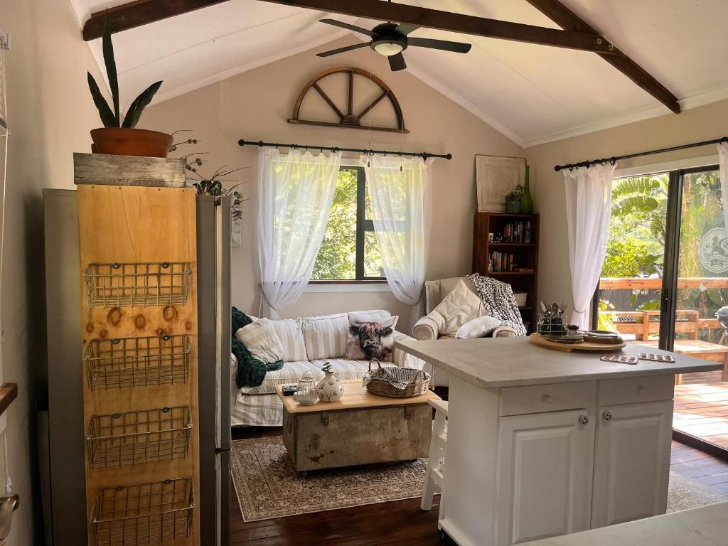 eine Küche und ein Wohnzimmer mit einer Couch und einem Tisch in der Unterkunft Griffin's Nest Cottage in Mbabane