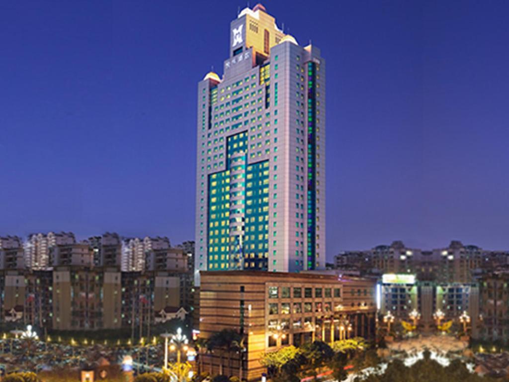 un edificio alto con luces verdes encima en C&D Hotel Quanzhou, en Quanzhou