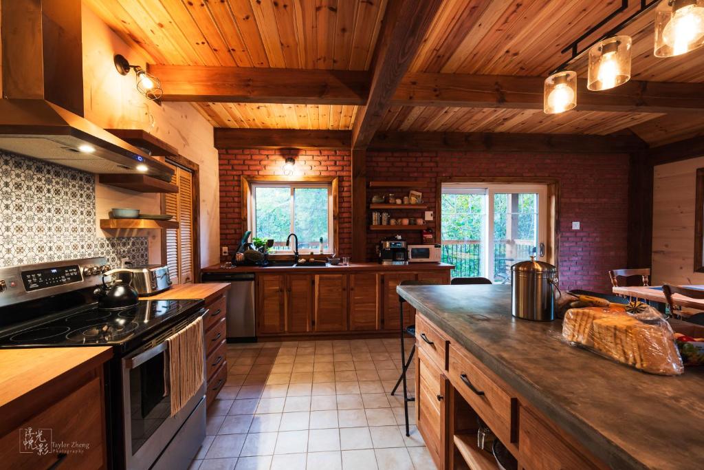 a large kitchen with wooden ceilings and wooden counters at Superbe maison à 1 kilomètre de la Marina in LʼAnse-Saint-Jean