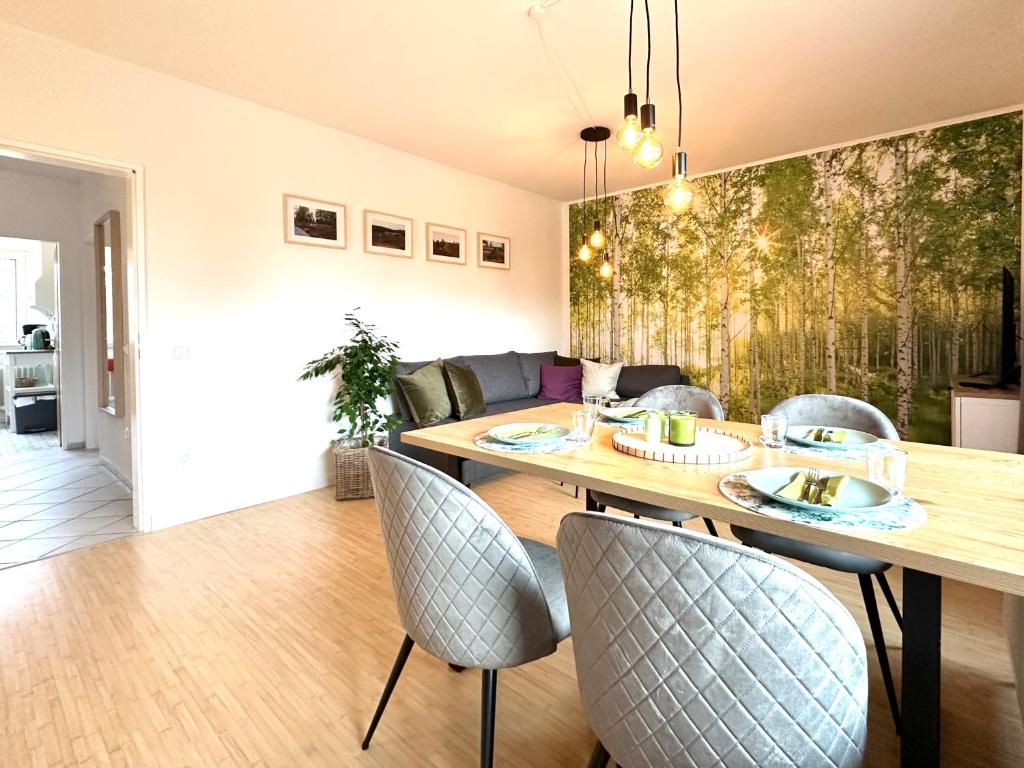 a dining room and living room with a table and chairs at HeideHygge 4 in Schneverdingen
