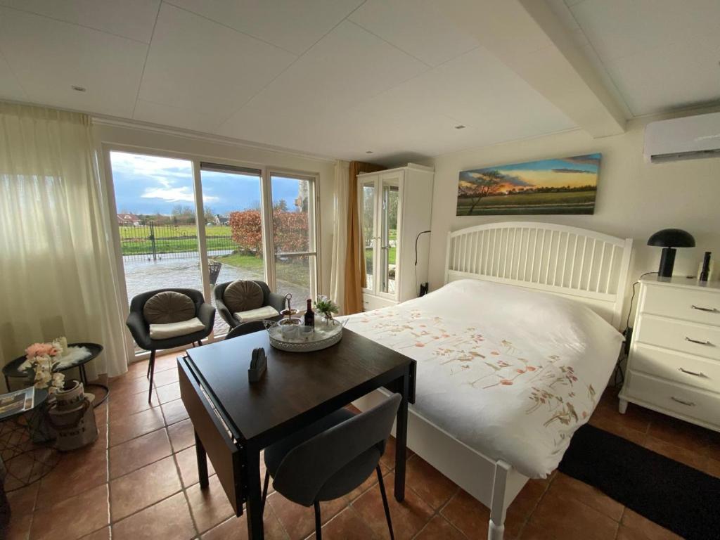 een slaapkamer met een bed en een tafel en stoelen bij De Veldeling in Hollandscheveld