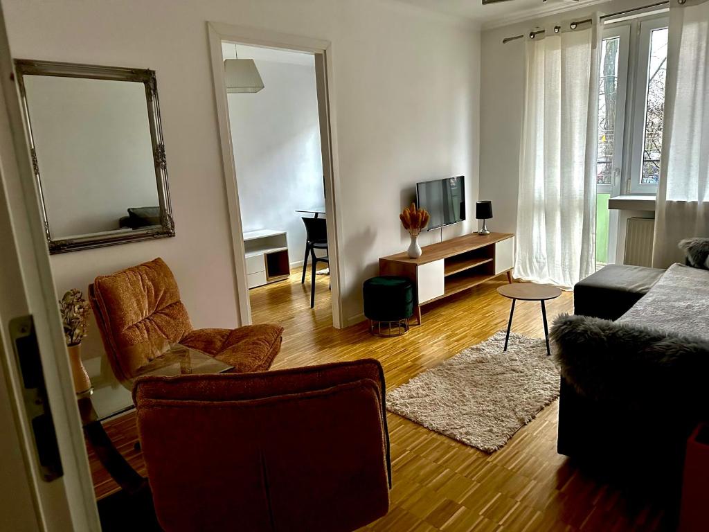 a living room with a couch and a tv at Przytulny Apartament z Balkonem Stalowa Wola in Stalowa Wola