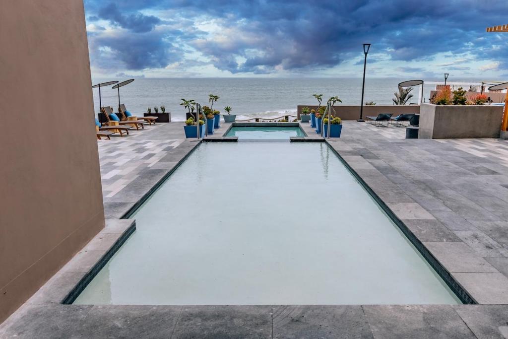 a swimming pool with the ocean in the background at Beachfront Condo with Balcony amazing view in Tijuana