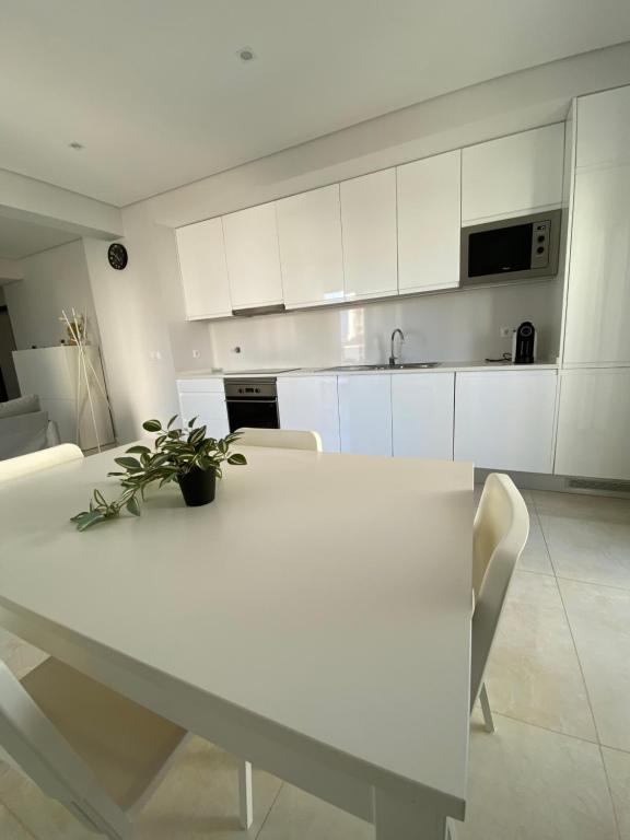 una cucina bianca con tavolo e sedie bianchi di Iate Residence a Portimão