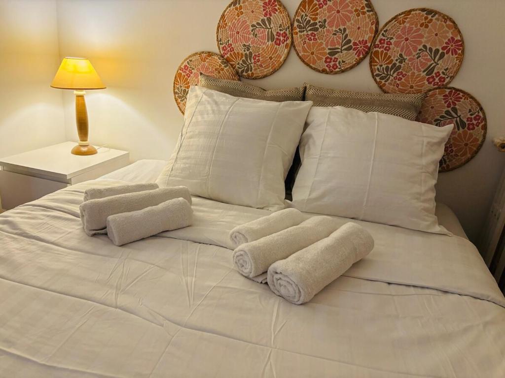 a white bed with towels on top of it at Nid Asnières escapade cosy aux portes de Paris in Asnières-sur-Seine