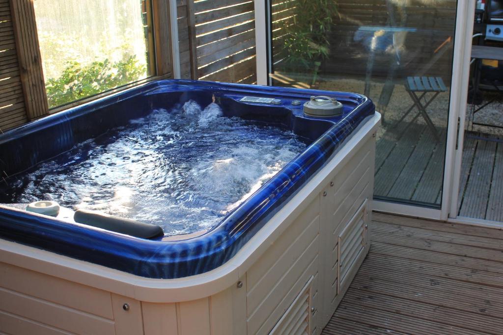 - un bain à remous installé sur une terrasse couverte dans l'établissement Petit chalet climatisé avec jacuzzi privé, au Beausset