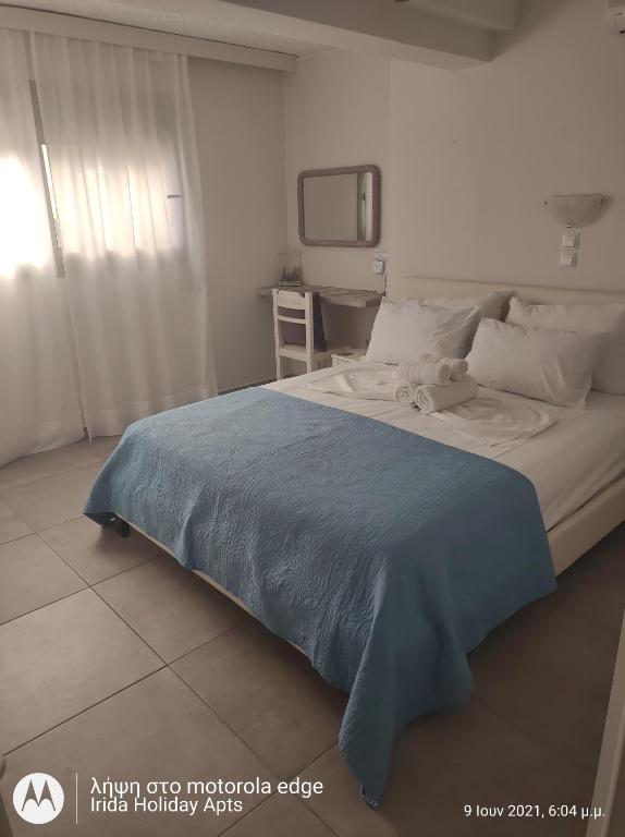 A bed or beds in a room at Irida Holiday Apartments