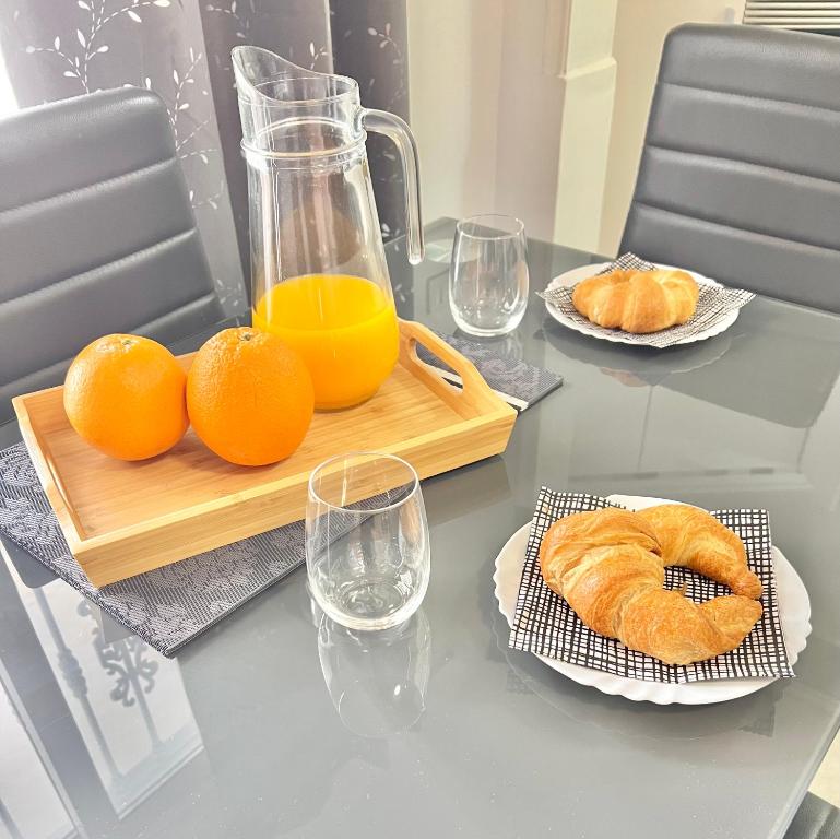 a table with oranges and a jug of orange juice and croissants at Imperial Villas I Casa Yei in Puerto del Carmen