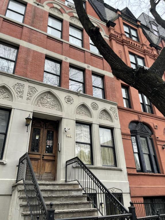a brick building with stairs leading to a door at NYC Townhouse Apartment in New York