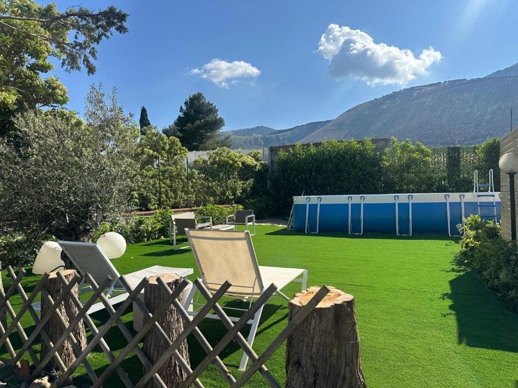 een tuin met een hek en stoelen op een gazon bij Villa Emma in Palermo