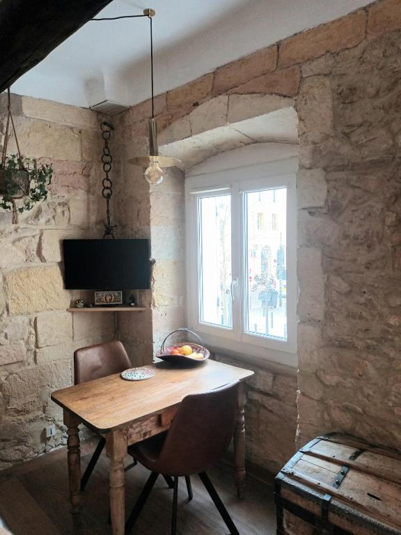 une salle à manger avec une table en bois et une fenêtre dans l'établissement Charmant studio Vieux Port, à Marseille