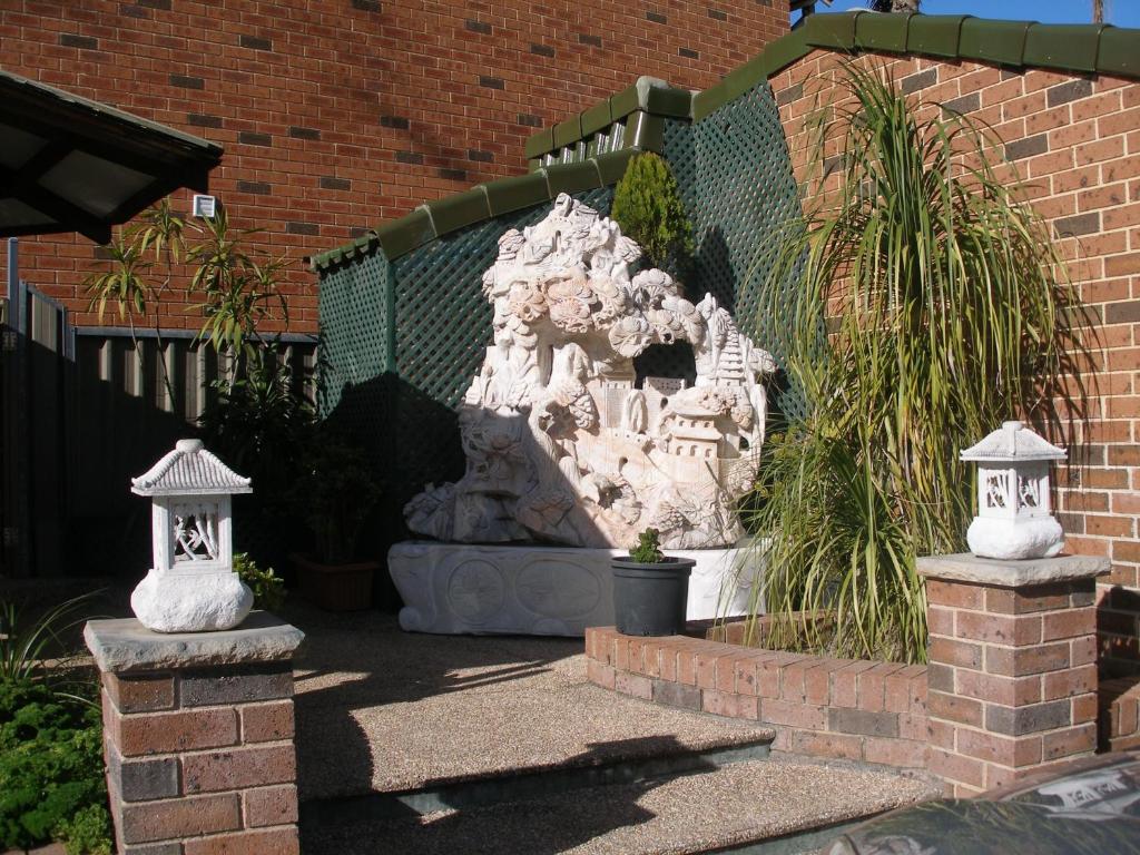 una fuente de piedra en el patio de un edificio en Mt Kuring-Gai Motel, en Mount Kuring-Gai