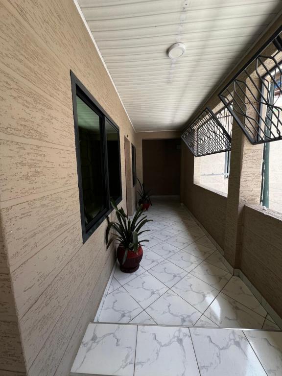 a hallway of a building with a potted plant at Hadraj Clocktower Studio Apt in Arusha