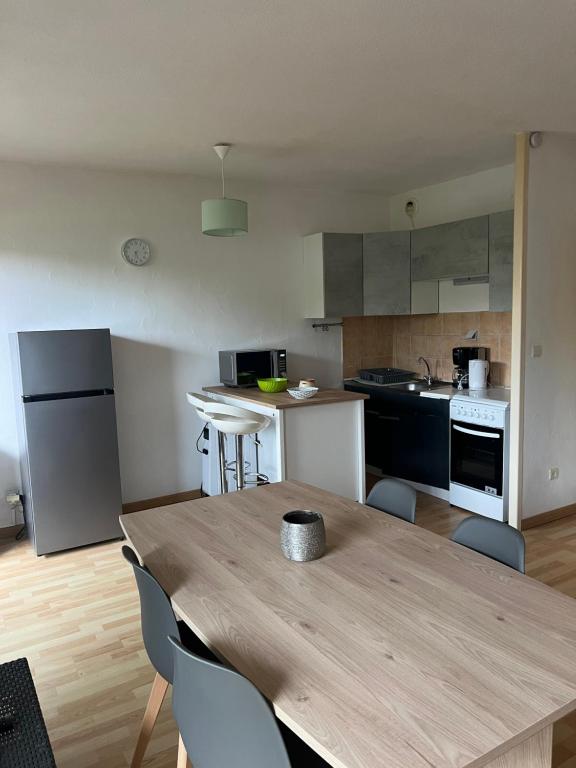 une cuisine avec une table en bois et des chaises. dans l'établissement Studio cabine près de la plage, au Lavandou