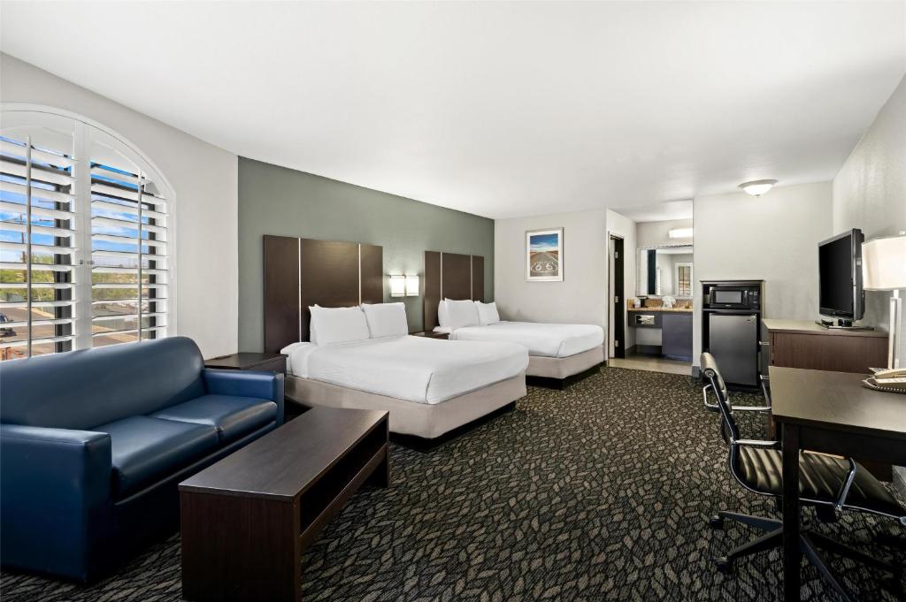 une chambre d'hôtel avec deux lits et un canapé dans l'établissement Best Western Desert Villa Inn, à Barstow