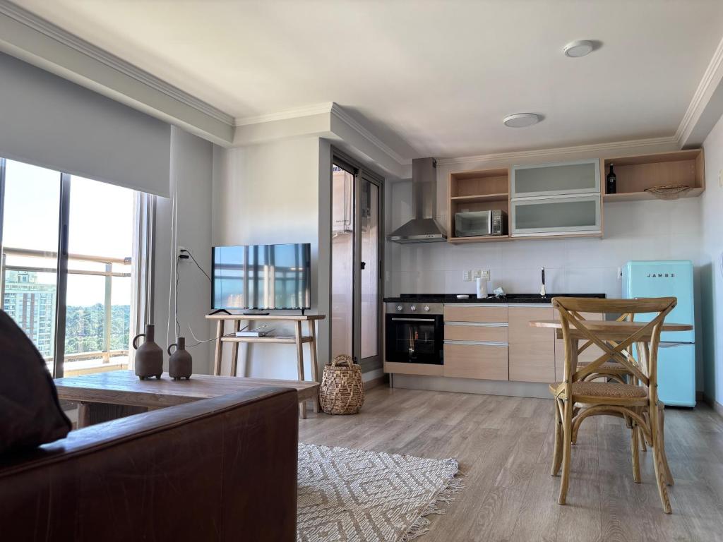 a kitchen with a table and chairs in a room at Place Lafayette piso 19 con espectacular vista Punta del Este in Punta del Este
