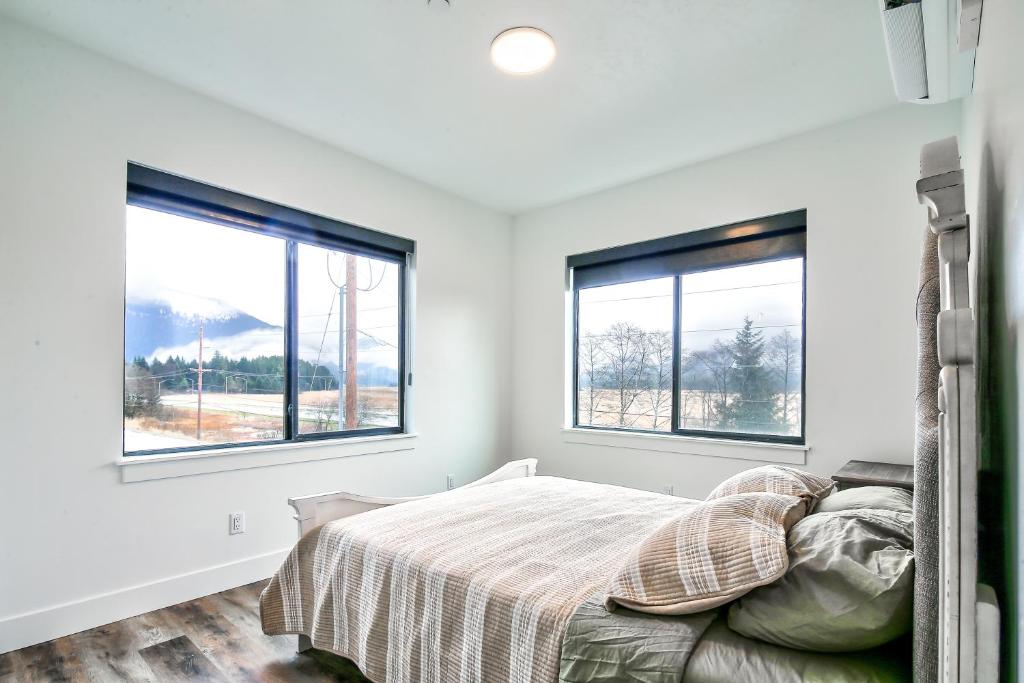 a bedroom with a bed and two windows at Cozy Luxury Close to Downtown 204 in Juneau