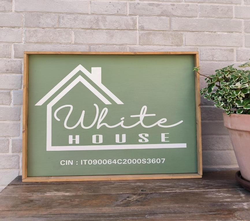 a sign for a white house on a brick wall at White House in Sassari