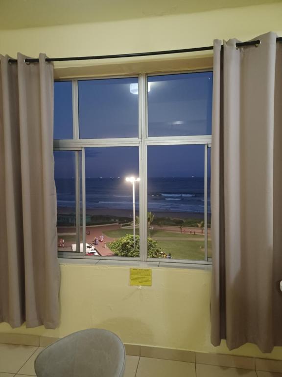 a window with a view of the ocean at Frontline Holiday apartment in Durban