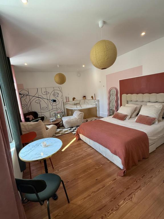 a bedroom with a large bed and a table at Mini loft Spa - Cosy in Dijon