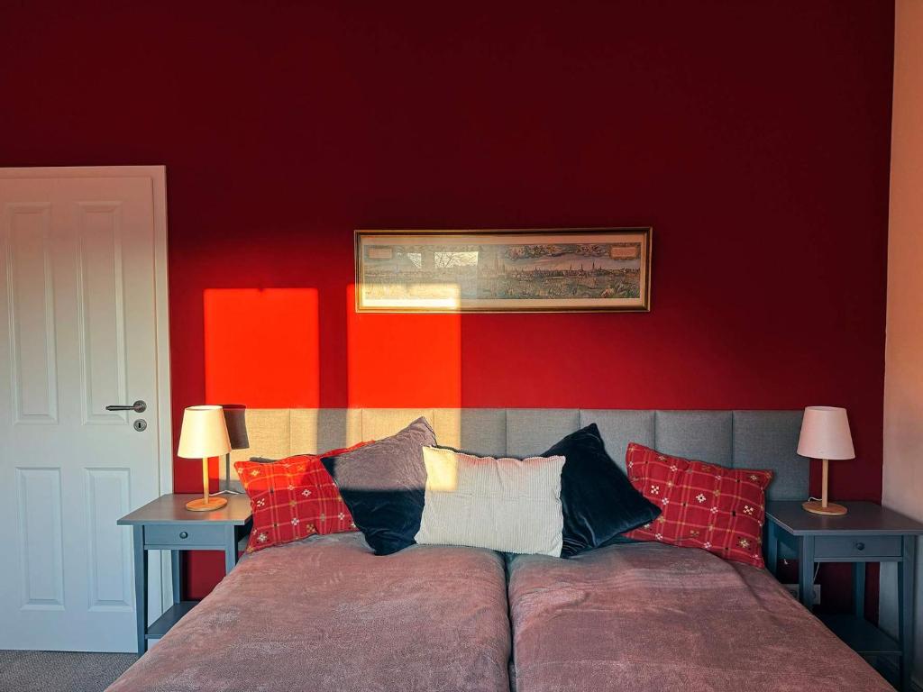 a bedroom with red walls and a bed with pillows at Big Premium Apartment with Rhine View, totally new in Duisburg