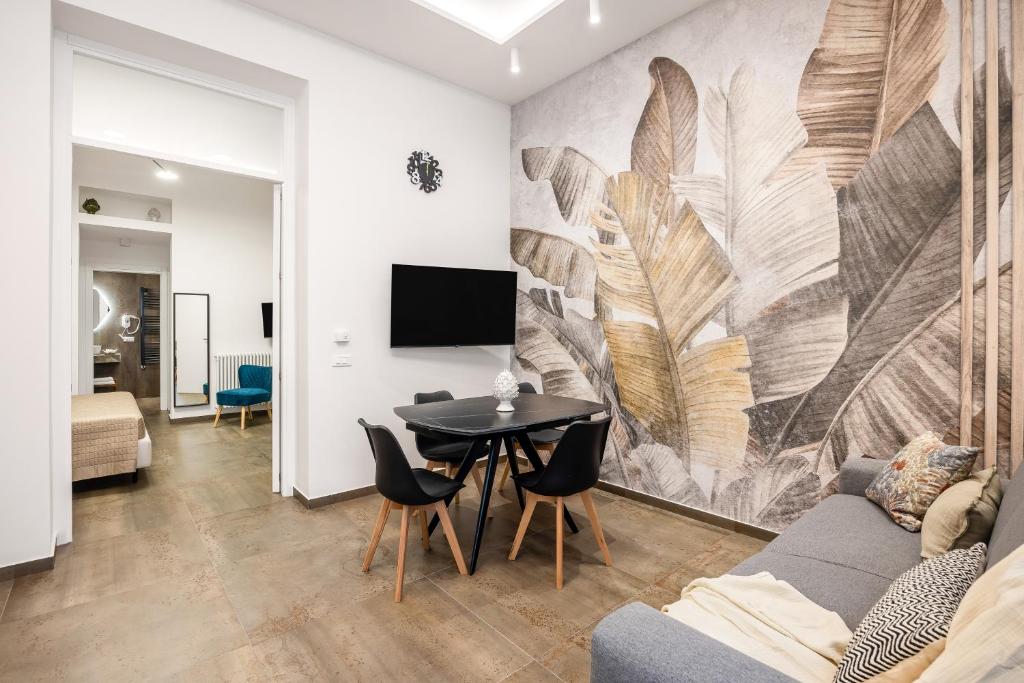 a living room with a table and a wall mural at Casta Diva Fervore Apartments Self Check-in in Palermo