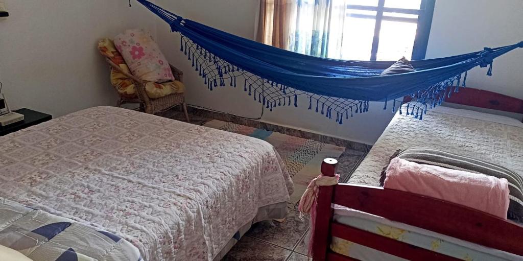 a bedroom with two beds and a blue net at Portais São Thomé casa de temporada in São Thomé das Letras