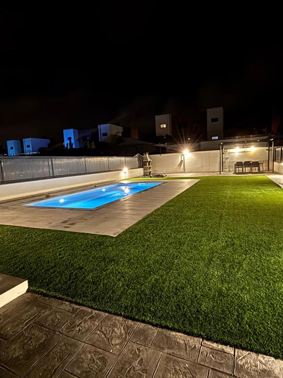 a backyard with a swimming pool at night at Casa con piscina y parking en Roda de Berà in Roda de Bará