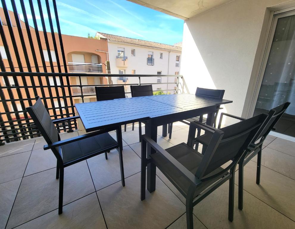 une table bleue et des chaises sur un balcon dans l'établissement Le Terra Tosca, bel appartement, 2 pas de la plage, à Fréjus