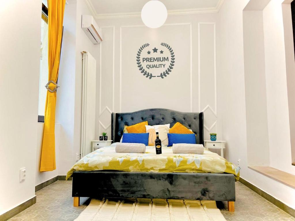 a bedroom with a bed with yellow and blue pillows at Central ZEN apartament in Cluj-Napoca