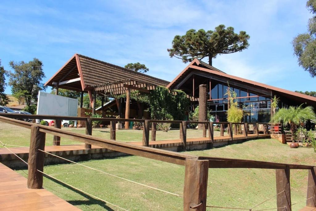 a wooden fence in front of a building at Hotel O Recanto in Campo Mourão