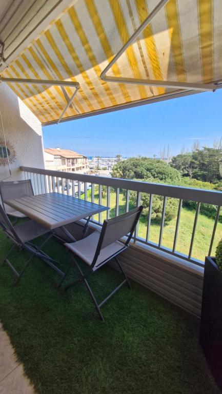 une table de pique-nique et deux chaises sur un balcon dans l'établissement Véritable pépite proche plage et port, à Saint Cyprien Plage