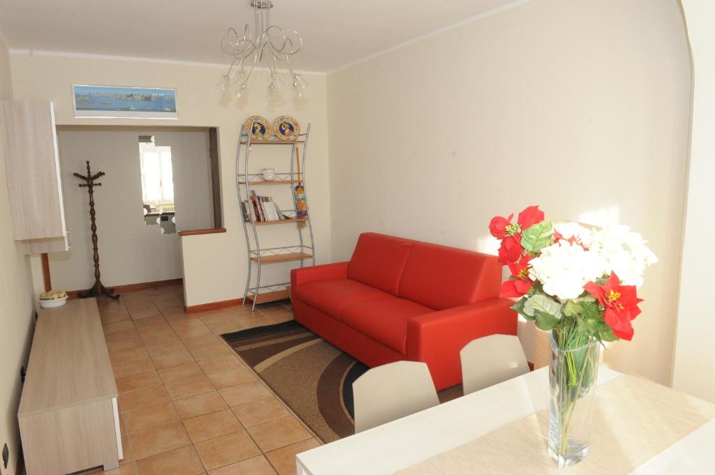 a living room with a red couch and a vase of flowers at Casa da Mary in Iseo