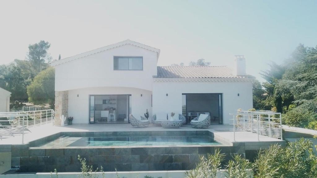 a white house with a pool in front of it at Villa Bali, magnifique vue mer et Esterel in Saint-Aygulf