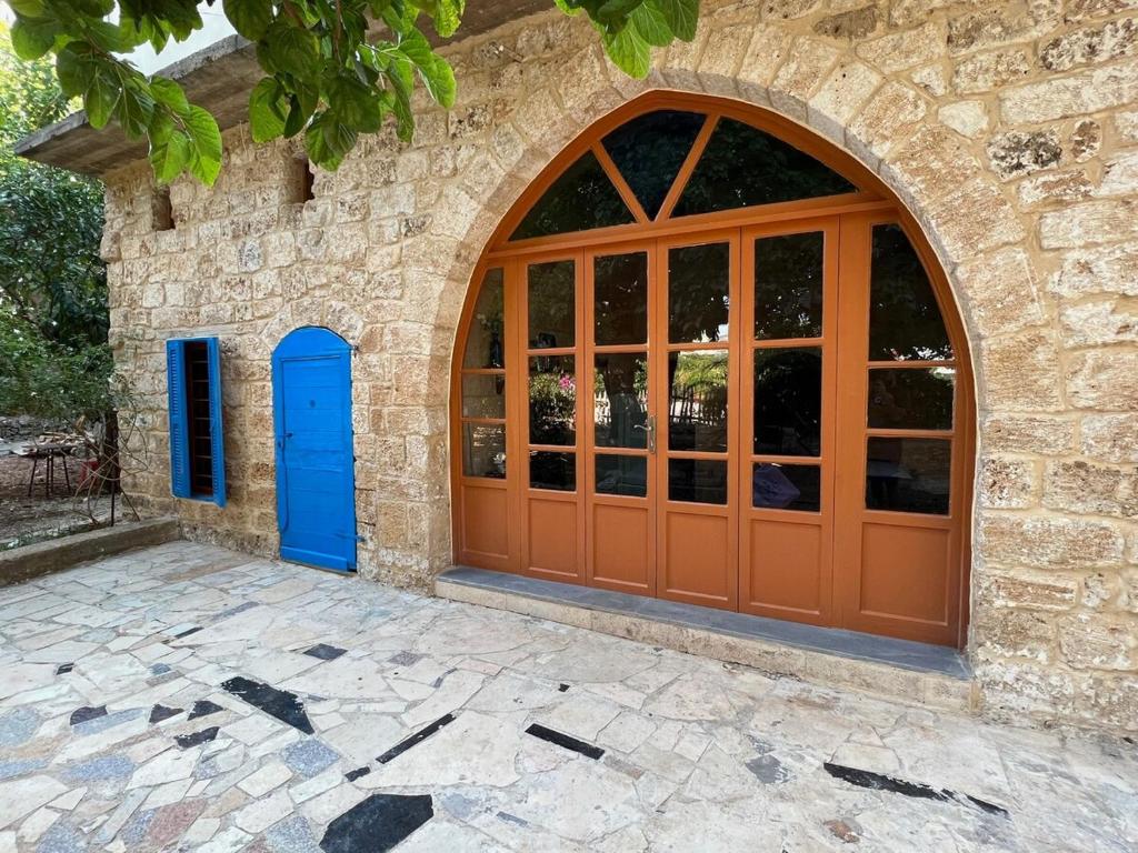 een ingang naar een stenen gebouw met een houten deur bij Beit Tout Guesthouse in Saïda