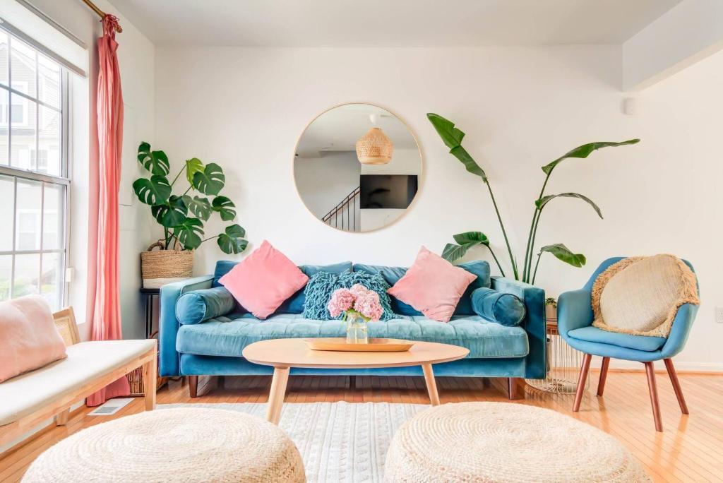 a living room with a blue couch and a round mirror at Walk to the Beach! Beach Passes | Games I King Bed in North Beach